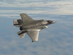 An F-35B JSF flies tests flying with missiles.