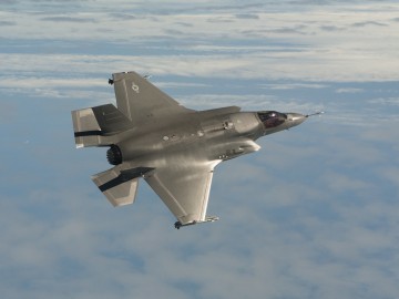 An F-35B JSF flies tests flying with missiles.